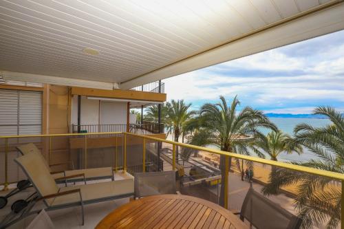 a balcony with a view of the ocean and palm trees at DIFFERENTFLATS Barcino in Salou