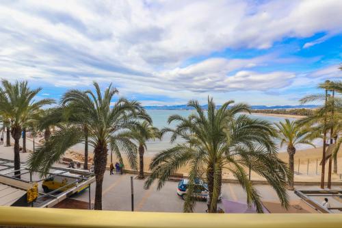 vistas a una playa con palmeras y agua en DIFFERENTFLATS Barcino, en Salou