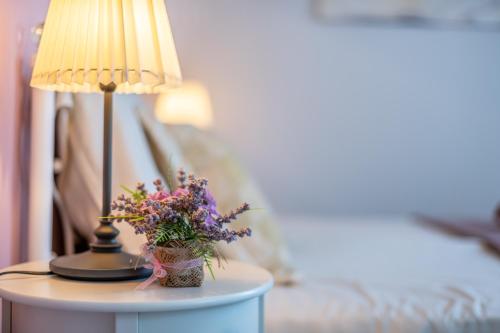 a table with a lamp and a vase of flowers on it at Old city Romantic studios 4 with FREE private parking in Pula