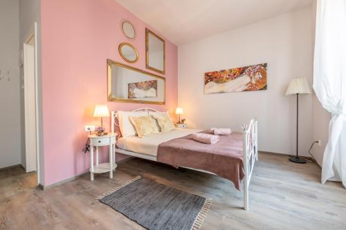 a pink bedroom with a bed and a table at Old city Romantic studios 4 with FREE private parking in Pula