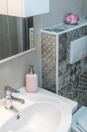 a bathroom with a sink and a pink soap dispenser at Old city Romantic studios 4 with FREE private parking in Pula