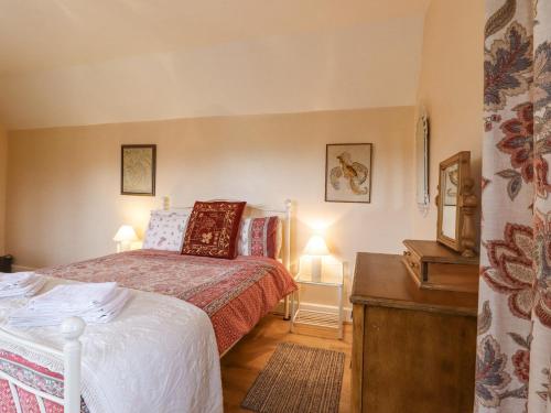 a bedroom with a bed and a table with two lamps at Hop House in Hastings