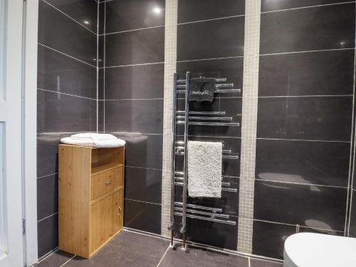 a bathroom with black tiled walls and a shower at Hop House in Hastings