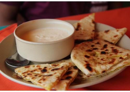 WelcomHeritage Mandir Palace في جيلسامر: طبق من الطعام مع وعاء من الحساء والمقرمشات