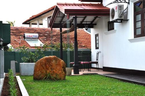 a large rock sitting in the yard of a house at Mama Villa Hikkaduwa in Hikkaduwa