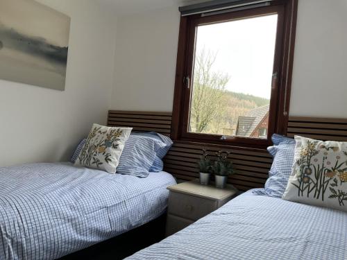 a bedroom with two beds and a window at Caledonia Lodge in Spean Bridge