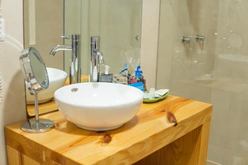 a bathroom with a white bowl sink on a wooden counter at Cooper Hotel Boutique in Cusco
