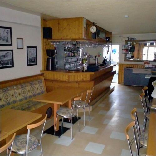 ein Restaurant mit Tischen und Stühlen und eine Bar in der Unterkunft Hotel du Centre in Châlus