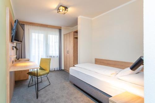 Schlafzimmer mit einem Bett, einem Schreibtisch und einem Stuhl in der Unterkunft Hotel Schwan in Pottenstein