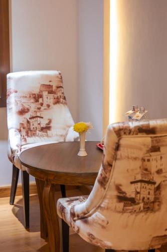 a table and a chair with a vase on it at Hotel Ama-La, Thamel, Kathmandu in Kathmandu