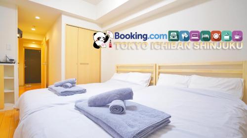 a bedroom with two beds with towels on them at TOKYO ICHIBAN SHINJUKU in Tokyo