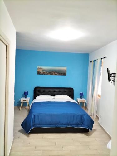 1 dormitorio azul con 1 cama y 2 mesas en Blue House Napoli, en Nápoles