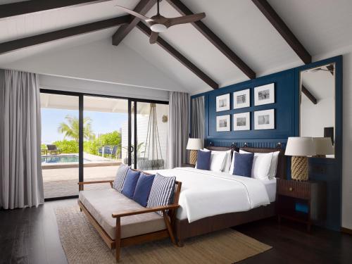 a bedroom with a large bed with blue walls at Villa Nautica Paradise Island Resort in North Male Atoll