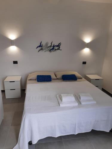 1 dormitorio con 1 cama blanca grande y 2 mesitas de noche en Cà gialla de Drignana, en Vernazza