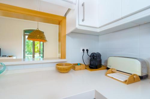 a kitchen with a counter with a sink and a mirror at Casa Verde Sal in Alcácer do Sal