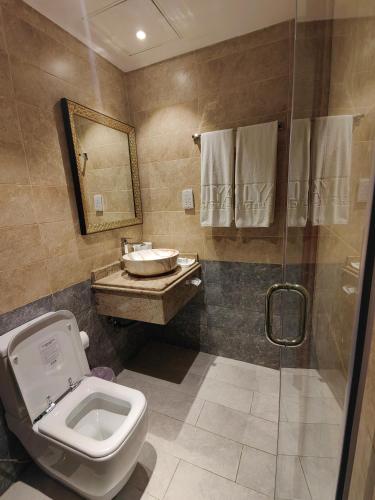 a bathroom with a toilet and a sink and a shower at ALYA Hotel in Barka