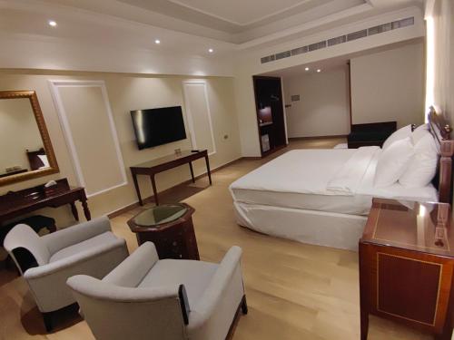 a large hotel room with a large bed and chairs at ALYA Hotel in Barka