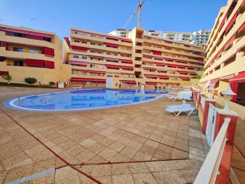 a large building with a swimming pool in front of it at sol y mar in Puerto de Santiago