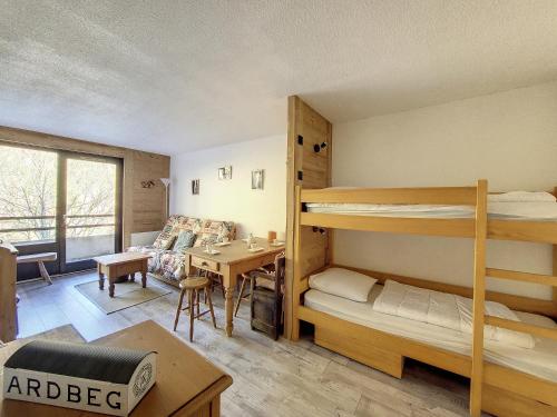 Zimmer mit Etagenbetten und einem Wohnzimmer mit einem Tisch in der Unterkunft RELAIS s30 in Saint-Jean-dʼAulps