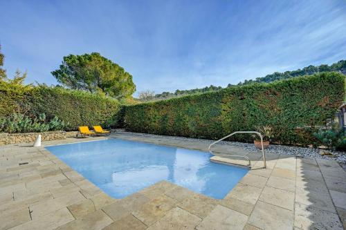 - une piscine dans une cour avec une haie dans l'établissement La Bastide des Jourdans - Piscine et climatisation, à La Bastide-des-Jourdans
