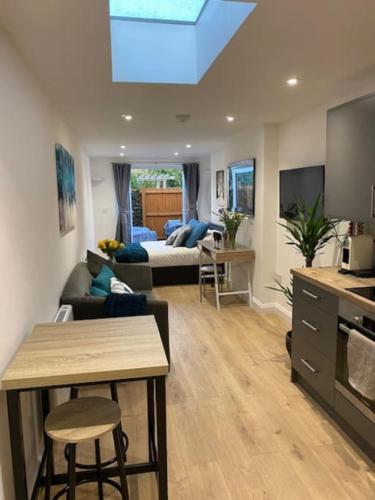 a living room with a couch and a bed in a room at Stylish 1 bedroom studio outdoor area and hot tub in Bournemouth