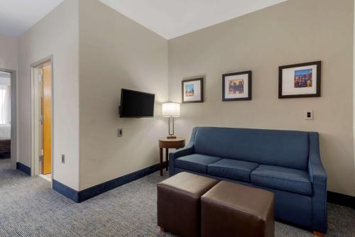 a living room with a blue couch and a tv at Comfort Suites Stockbridge Atlanta South in Stockbridge