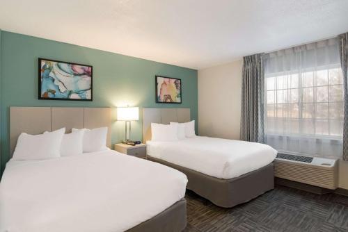 a hotel room with two beds and a window at MainStay Suites Omaha Old Mill in Omaha