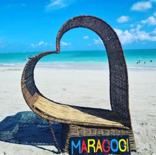 a chair sitting on the beach near the ocean at Manancial Flats in Maragogi