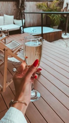a woman holding a glass of wine on a table at Brown Beach House Tel-Aviv, a member of Brown Hotels in Tel Aviv