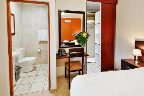 a hotel room with a bed and a bathroom at The Venue Country Hotel & Spa in Hartbeespoort