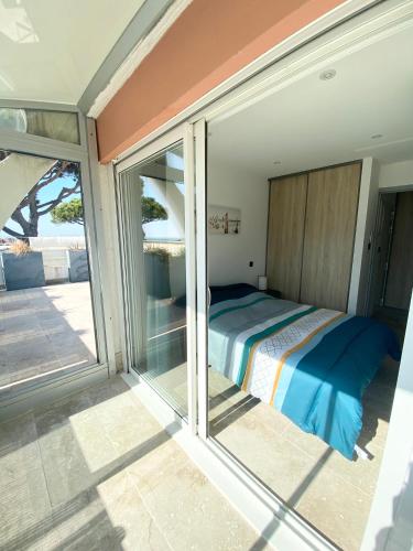 - une chambre avec un lit à côté d'une porte coulissante en verre dans l'établissement AS23077-Marina P3-vue mer, grande terrasse,parking, au Grau-du-Roi
