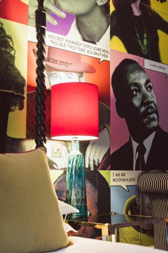 a lamp in front of a wall with a poster at The Rutland Hotel & Apartments in Edinburgh