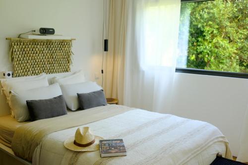 a bedroom with a bed with a hat on it at Villa Várzea - The Black Cabin in Várzea