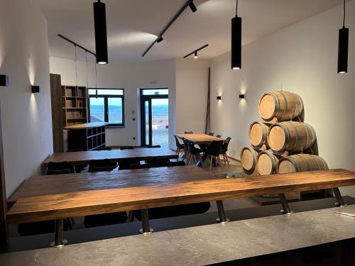 Cette chambre dispose d'une table en bois et d'une table avec des tonneaux de vin. dans l'établissement Johannesberg, à Zaječí