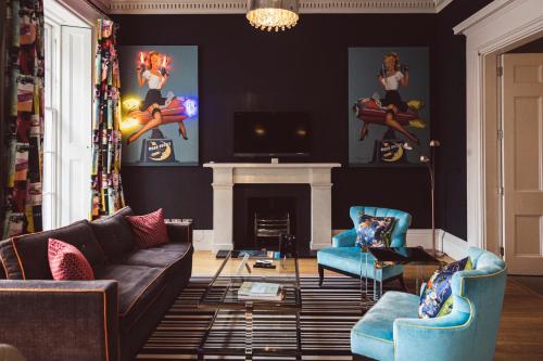 a living room with a couch and a fireplace at The Rutland Hotel & Apartments in Edinburgh