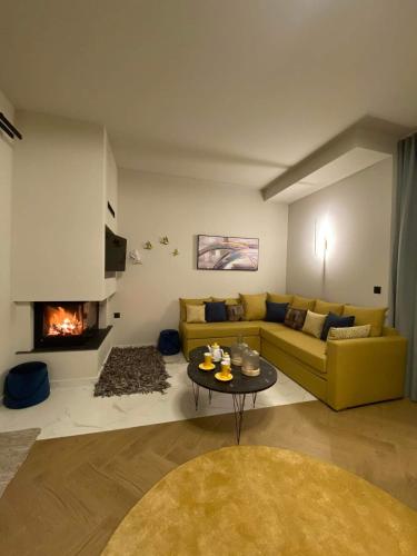 a living room with a yellow couch and a fireplace at Luxury Villas Chrysa Private Pool & Spa in Nafplio