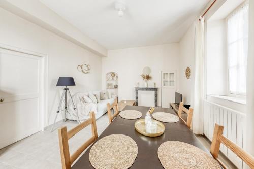 une salle à manger avec une table, des chaises et un canapé dans l'établissement T2 calme avec Parking privé - 20 min Versailles - Paris à la campagne, à La Queue-lès-Yvelines