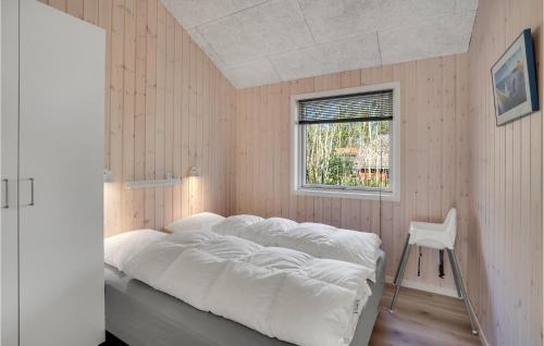 een bed in een kamer met een raam en een stoel bij Amazing Home In Oksbl With Indoor Swimming Pool in Oksbøl
