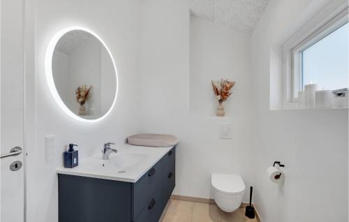 een badkamer met een wastafel, een toilet en een spiegel bij Amazing Home In Oksbl With Indoor Swimming Pool in Oksbøl