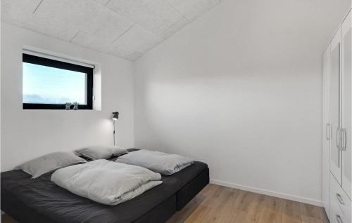 a bed in a white room with a window at Beautiful Home In Thisted With Sauna in Thisted