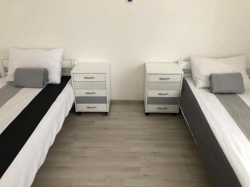 two beds in a room with two night stands at MiJa apartmán s VINNÝM SKLÍPKEM, zahradou a grilem in Kájov