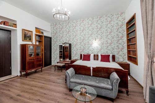 een slaapkamer met een bed, een bank en een tafel bij VovaDoma in Tbilisi City