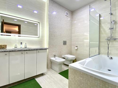 La salle de bains est pourvue d'une baignoire, de toilettes et d'un lavabo. dans l'établissement Coquette Apartment, à Braşov