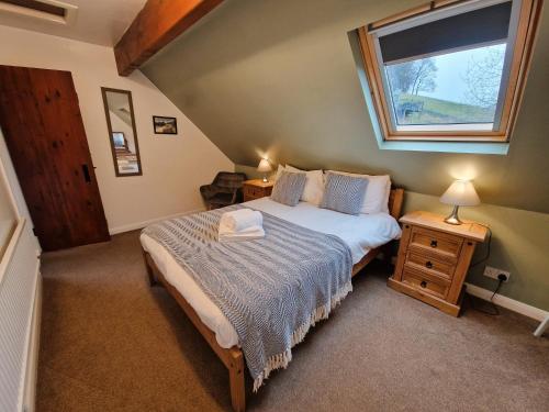 a small bedroom with a bed and a window at Twitchill Farm Holiday Cottage in Hope