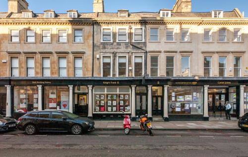 two people on bikes parked in front of a building at City Centre Stunning House-Roman Baths - 3min walk - 4 Bedrooms in Bath