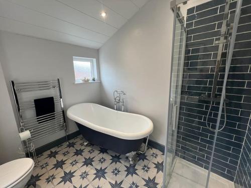 a bathroom with a bath tub and a toilet at The Boathouse - Hottub - Sleeps 6 in Woodhorn