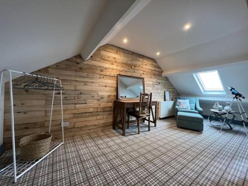 a room with a wooden wall with a desk and a chair at The Boathouse - Hottub - Sleeps 6 in Woodhorn