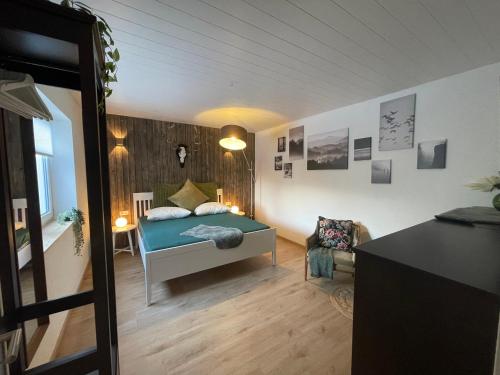 ein Schlafzimmer mit einem Bett und einem Stuhl in einem Zimmer in der Unterkunft Ferienwohnung „Haus Herbert“ Wohnung „Emma“ 