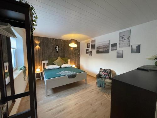 una camera da letto con un letto e una sedia in una stanza di Ferienwohnung „Haus Herbert“ Wohnung „Emma“ a Langsdorf