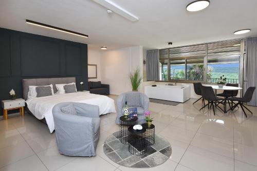 a bedroom with a bed and a table and chairs at אדם וחווה - סוויטות מפנקות עם ג'קוזי פרטי ובריכה במתחם מול נוף גלילי מושלם in Gornot HaGalil